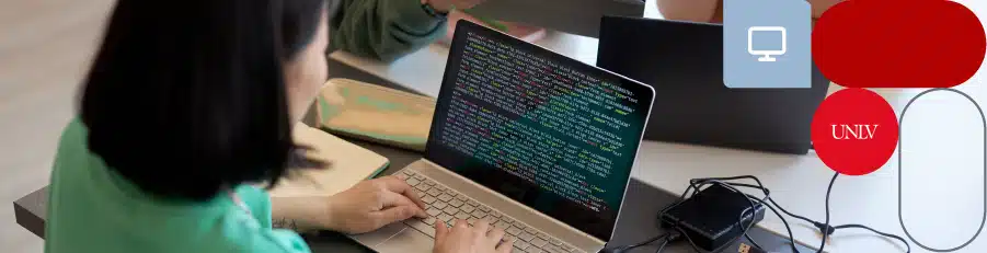 "Person coding on a laptop in a classroom setting, highlighting cybersecurity education."