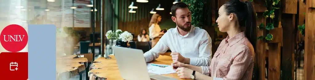 Two people working on a laptop in a cafe